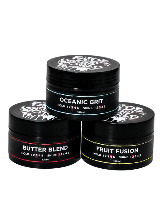 Three black hair product jars labeled 'Oceanic Grit', 'Butter Blend', and 'Fruit Fusion' on a white background.
